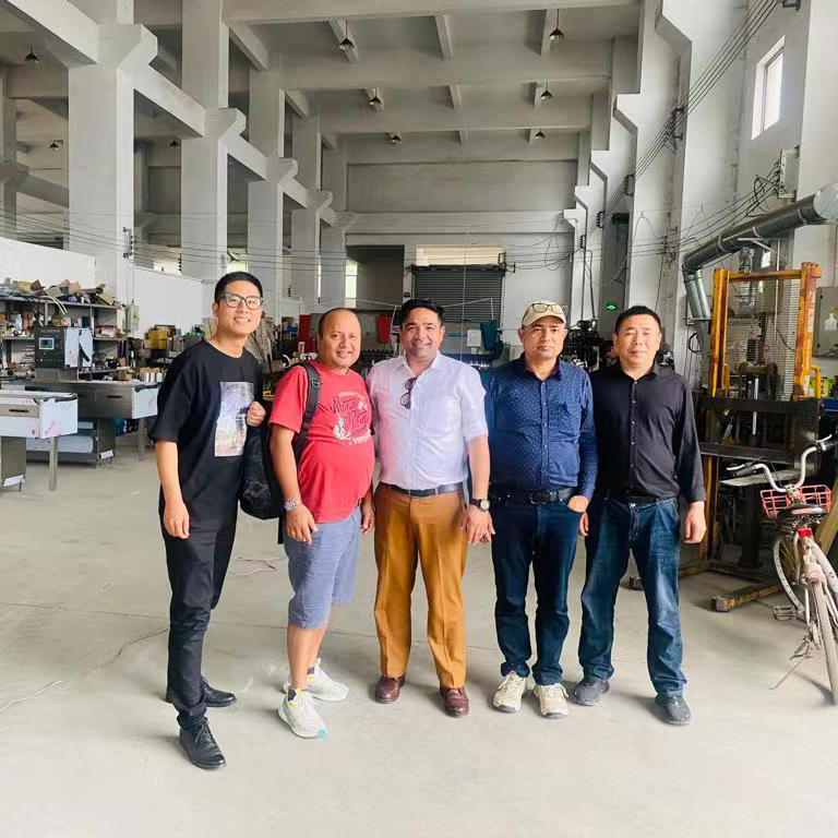 Drie Nepalese kliënte kom na ons fabriek om hoenderblokkie-druk verpakkingsmasjien te besoek