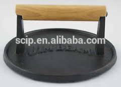 round Cast iron meat grill press with wooden handle.