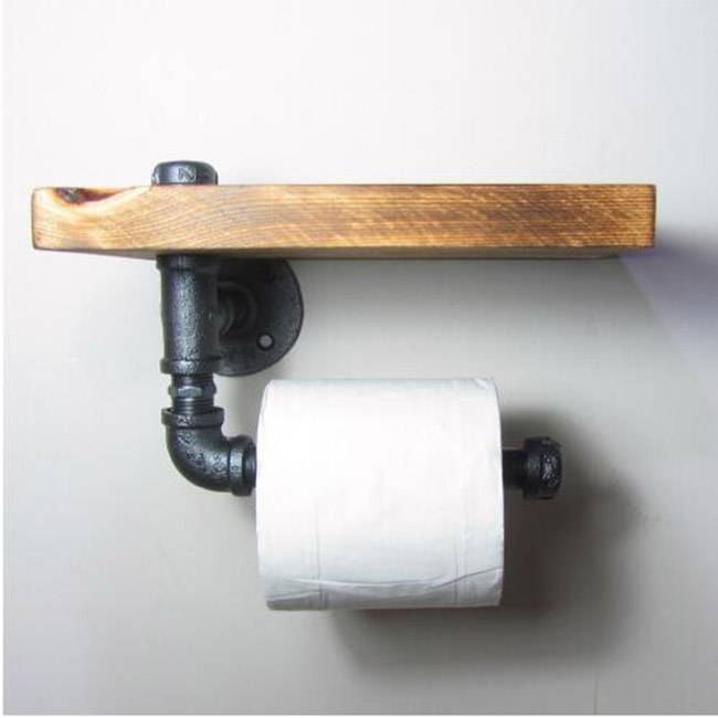 Black wrought iron pipes and floor flange used in toilet paper holder
